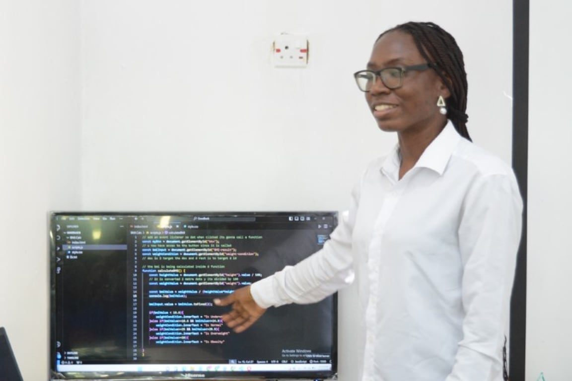 A Toko Academy trainer working through JavaScript on screen with the class
